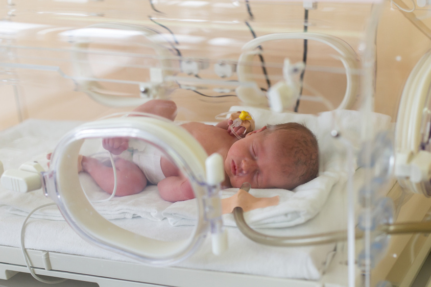Young boy helps dad to keep his newborn twin siblings warm in viral photo